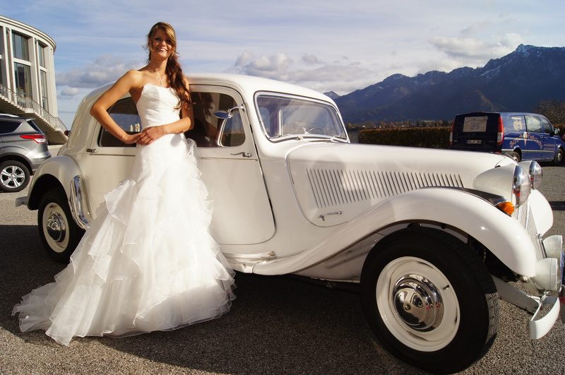 Braut im Prinzessinnenkleid vor einem Oldtimer
