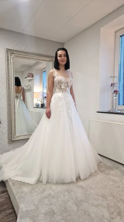Brautkleid mit Tüllrock und Spitze vor dem Spiegel