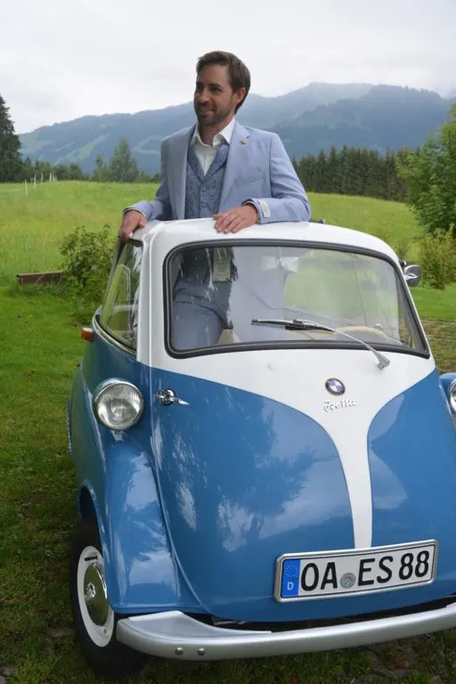 Herr im hellblauen Anzug an einer BMW Isetta